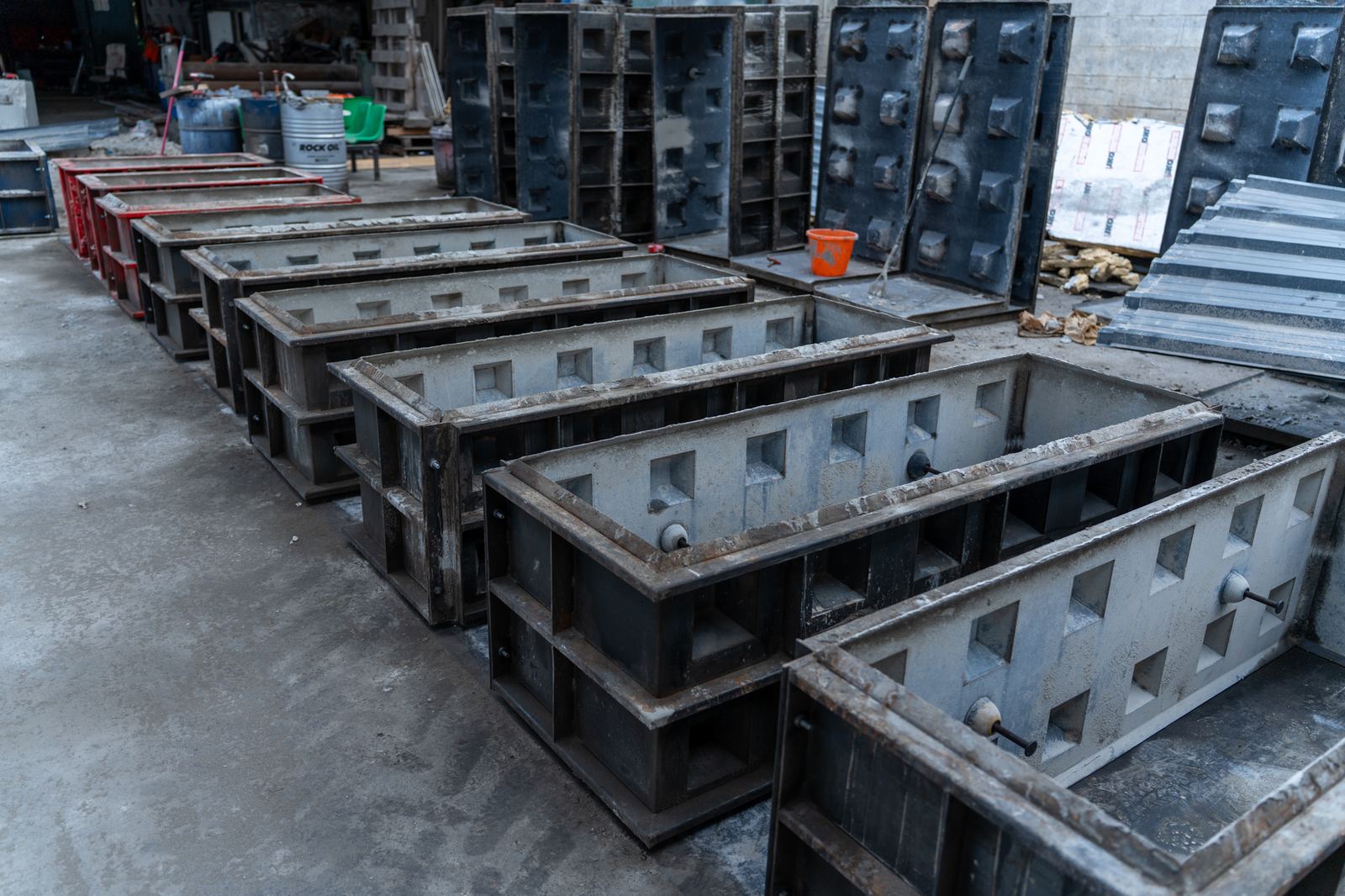 Row of steel moulds used to cast interlocking concrete blocks